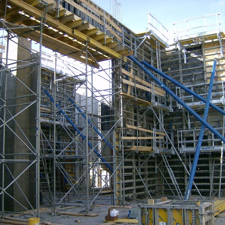 Betonkonstruktion im Bau mit Gerüst und Arbeitskräften, Baustelle, modernes Bauprojekt, Rohbau, Hochbau, Schaffung neuer Gebäude, Baufortschritt.