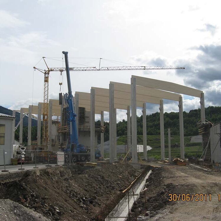 Betonbau und Bauarbeiten im Baufortschritt, Baustelle mit Kran, Holzrahmen und Baugerüsten, Entwicklung eines modernen Gebäudes im ländlichen Gebiet, Bauprojekt im Fortschritt, kreative Architektur im Entstehen.