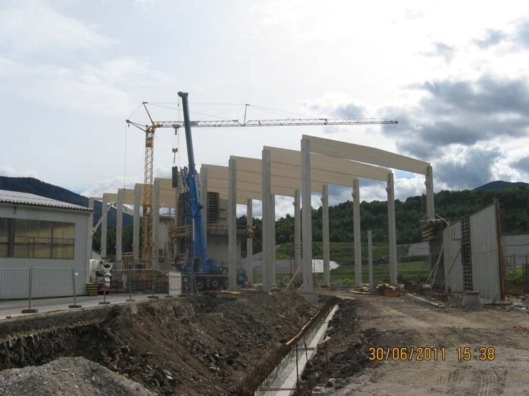 Betonbau und Bauarbeiten im Baufortschritt, Baustelle mit Kran, Holzrahmen und Baugerüsten, Entwicklung eines modernen Gebäudes im ländlichen Gebiet, Bauprojekt im Fortschritt, kreative Architektur im Entstehen.