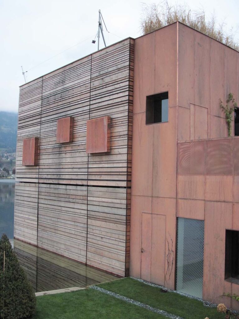 Moderne Holzwandfassade eines Gebäudes mit vertikalen und horizontalen Linien, minimalistisches Design, umweltfreundliche Bauweise, ansprechend für nachhaltiges Bauen.