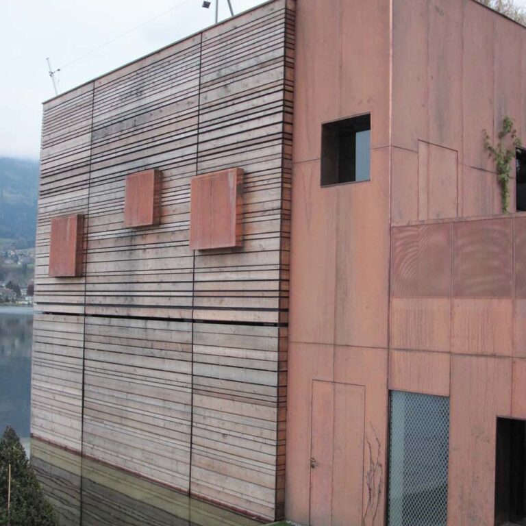 Moderne Holzwandfassade eines Gebäudes mit vertikalen und horizontalen Linien, minimalistisches Design, umweltfreundliche Bauweise, ansprechend für nachhaltiges Bauen.