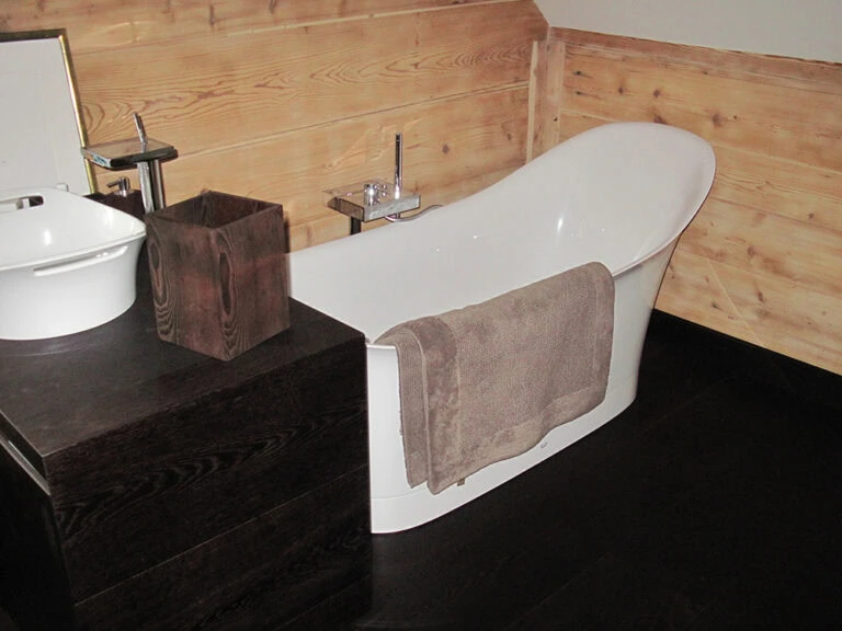 Entspannendes Badezimmer mit moderner Badewanne und Holzdekoration für ein gemütliches Ambiente.