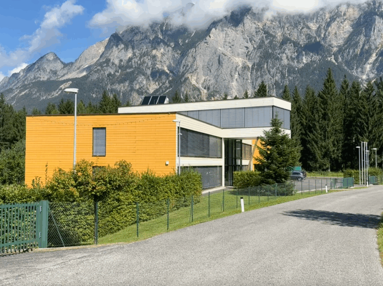 - Moderne Architekturfassade vor beeindruckender Bergkulisse im Naturpark Tirol.
