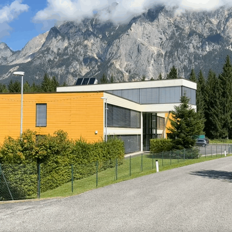 - Moderne Architekturfassade vor beeindruckender Bergkulisse im Naturpark Tirol.