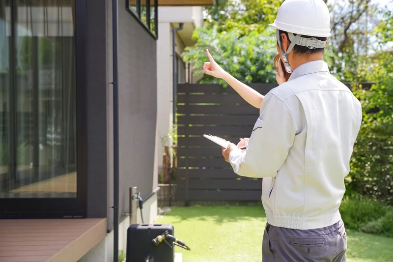 Bauüberwachung & Kontrolle Einen Bauinspektor oder Architekten in einem Garten bei einer Vor-Ort-Besichtigung.