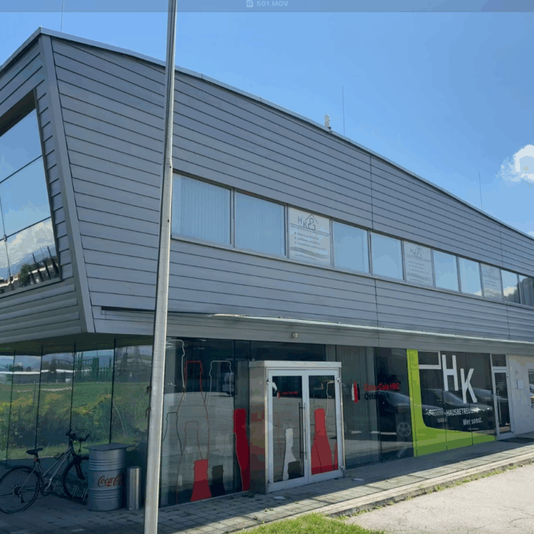 Neue moderne Geschäftsadresse im Gebäude mit Glasfassade und Firmenlogo für Hausbetreuungsdienste in Österreich.